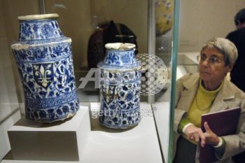 A woman looks at two jugs with shields (Syria, 15th century), presented in the exhibition The Song of the World, 02 October 2007 at the Musee du Louvre in Paris. The exhibition, which takes place from 05 October until 07 January 2008, outlines the evolution of art in Iran under the Safavid Dynasty (1501?1736) presenting a selection of masterpieces from the Aga Khan collection of Islamic art, as a preview to the opening of the Aga Khan Museum in Toronto. AFP PHOTO STEPHANE DE SAKUTIN