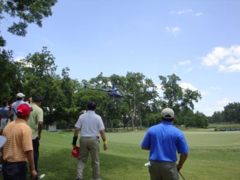 A helicopter is lowered as participants watch to see if their ball goes in the hole, for a chance to win a dirt bike.  Mohammad Virani was the lucky winner with First Insurance Company.