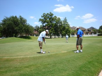 Golfers practice on the range prior to going out with 150 plus other golfers to raise awareness of Global Poverty.