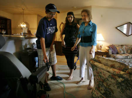 Ishan Mandani, 13, left, and his mother Nisha, 44, help Dolores Griffis, 80, at her home in Palm Harbor. Griffis receives assistance through Morton Plant Mease network’s program which pairs volunteers with seniors at a high risk of hospital readmission.