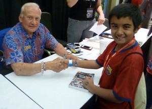 Qayl Maherali shakes hands with Astronaut Buzz Aldrin at Kennedy Space Center.