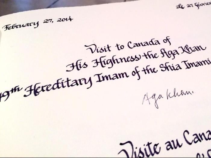 Aga Khan signs a book upon arriving at the House of Commons foyer