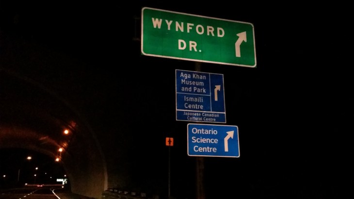 Road signs showing exits to the Ismaili Centre, Toronto, the Aga Khan Museum and their Park.