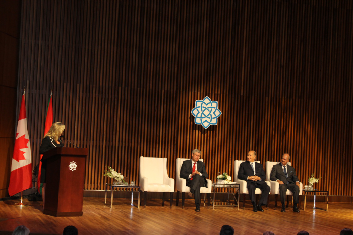 Minister of Canadian Heritage and Official Languages, Shelly Glover wishes Prince Amyn “Happy Birthday.” Left to right (standing at the podium) Minister Shelly Glover, (seated) Canadian Prime Minister Stephen Harper, His Highness Prince Karim Aga Khan and Prince Amyn Aga Khan. [Image © Ismailimail/AM]