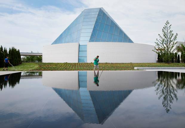 The Ismaili Centre is reflected in a pool as landscapers work in Aga Khan Park. (Darren Calabrese for The Globe and Mail)