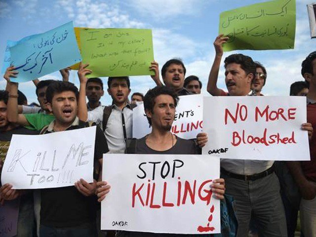 Pakistani civil society activists carry placards as they shout slogans during a protest against the killing of the Shiite Ismaili minority. (PHOTO: AFP via The Express Tribune)