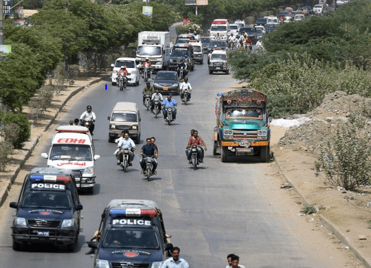 May 13, 2015 Pakistani security personnel escort ambulances carrying the bodies of Ismaili Muslims following the attack in Karachi. (Image credit: Asif Hassan/AFP/Getty Images via The Washington Post)