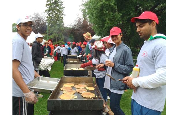 Hanif Kanji, right, prepares pancakes at the Ismaili Muslim community’s Canada Day pancake breakfast at the legislature Wednesday.