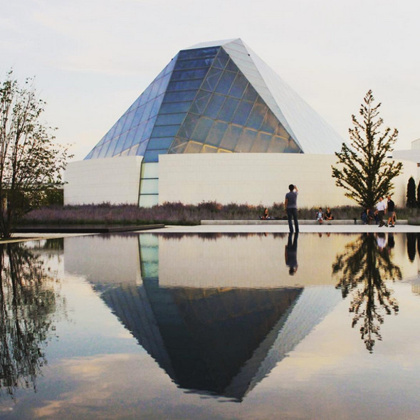 The serene looking Ismaili Centre, Toronto reflected in one of the 5 infinity pools between the Centre and the Aga Khan Museum, all embedded within the unifying Aga Khan Park. The combined spaces of the Aga Khan Museum and the Ismaili Centre, Toronto within the Aga Khan Park are dubbed as the Aga Khan Cultural Hub. (Image via Blog TO)