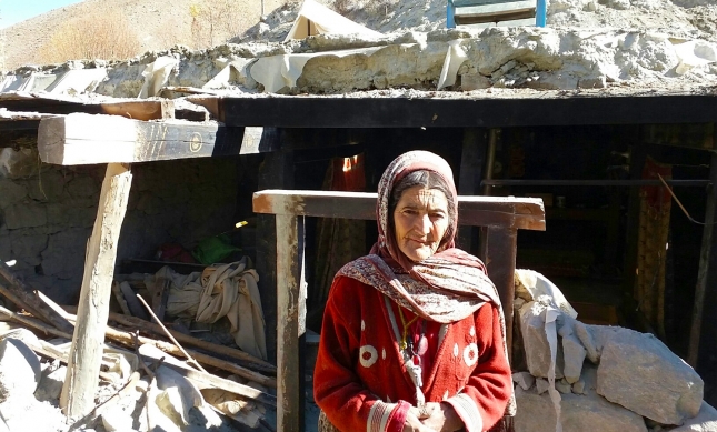 A woman in Phandar, Ghizer stands before the remnants of her home, which collapsed in the 26 October earthquake. FOCUS