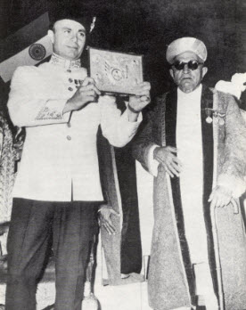 Prince Aly Khan displays the Platinum plaque which he received on behalf of his father on the occasion of his Platinum Jubilee celebrations in Bombay. Photo: Ilm, Centenary Issue, November 1977