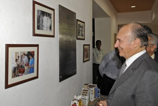 Mawlana Hazar Imam smiles as he looks at photographs of his visit to the Diamond Jubilee High School in 1958, and Princess Zahra's inauguration of the new site of the school in 2007. Photo: The Ismaili/Gary Otte