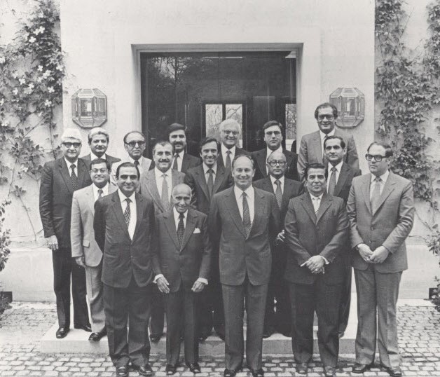 Mawlana Hazar Imam with Ismaili leaders at Aiglemont, 1982. First row, L to R:Vazir Badruddin Morani (India), Count Sir Eboo Pirbhai (Africa), Mawlana Hazar imam, Vazir Ramzan Merchant (Pakistan), Mr Tamer Tamer (Syria). Standing behind from L to R: Vazir Ameerali Rahimtoola (India), Mr. Shams Bhaloo (USA), Vazir Abdulmohamed Furniturewala (India), Vazir Mohammad Bhai (Bangladesh), General Moustapha Sharba (Syria), Mr Salim Issa (Portugal), Aitmadi Akbar Karmali (Pakistan), Mr Zulfikar Lalji (Canada), Mr Zulfikar Jiwa (Europe), Mr Jafferali Tejpar (Tanzania), Mr Kurban Bhaloo (Kenya), Rai Amir Bhatia (UK). Photo: 25 Years in Pictures