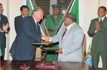 His Highness Prince Karim Aga Khan shaking hands with Tanzanian President Benjamin Mkapa (right) after signing an Agreement of Co-operation for Development. Image credit: AKDN / Gary Otte