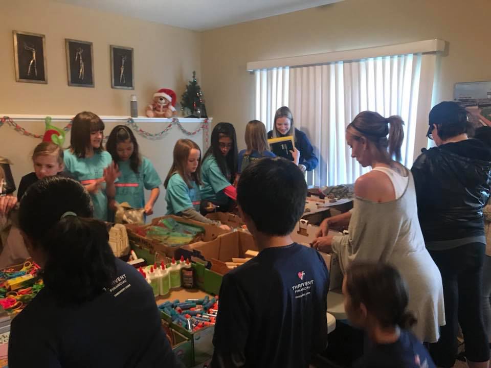 Local girl, volunteers pack bags for homeless children