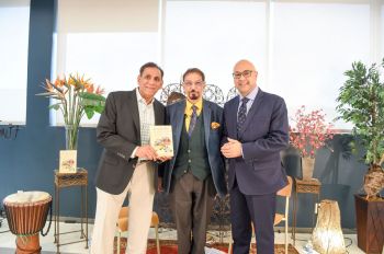 Iqbal Dewji of Khojawiki.org, holding "Diasporic Distractions", announces the official launch of the book as Mohamed Keshavjee and Ali Velshi look on.