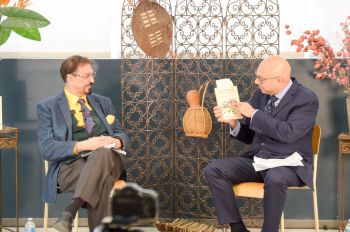 Aly Velshi moderating the session as Keshavjee explains the cover design. “The buses on the cover reflect movement. People in many societies tell their stories in buses. The very cargo, human and material, are what these stories are about”