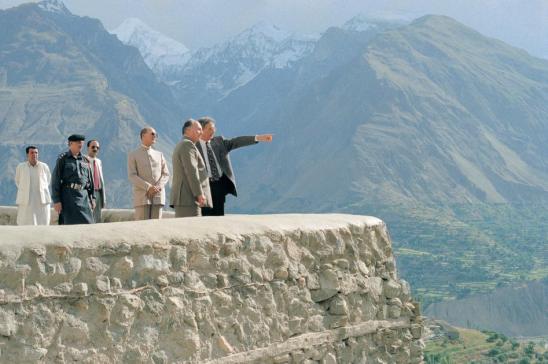 His Highness the Aga Khan, admiring the breath-taking view from the Baltit Fort, northern Paksitan, in conversation with Stefano Bianco, Director of Historic Cities Support Programme, part of the Aga Khan Trust for Culture. Prince Amyn Aga Khan looks on. 1996. The conservation of the over 700 years old Baltit Fort, the pre-eminent landmark  onument in Gilgit-Baltistan, and the rehabilitation of the historic core of the Karimabad village in the Hunza Valley, were the Aga Khan Historic Cities Programme first major interventions,  completed in 1996. These projects, as well as others in neighbouring Baltistan, have won a number of prestigious prizes, including the UNESCO Asia-Pacific Heritage Awards for Cultural Heritage Conservation (every year between 2002 and 2013); a Time Magazine “Best of Asia”; and a British Airways Tourism for Tomorrow Award. The Aga Khan Trust for Culture has completed dozens of other restoration projects in Baltistan and Hunza, but the area remains a treasure trove of scores of shrines, forts, mosques and other buildings of cultural and historical significance. - Photo credit: AKDN / Gary Otte