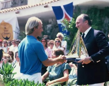 Porto Cervo, Sardinia, Italy. 1987: His Highness Prince Karim Aga Khan IV presenting the most coveted award in 12mR sailing competition - Azzurra Trophy, to David Barnes, skipper of the 1987 12mR World Champion team sailing KZ-7. Image credit: PJ Montgomery via ITMA
